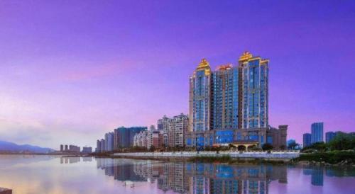 a city with tall buildings next to a body of water at Hampton by Hilton Zhuhai Doumen in Zhuhai