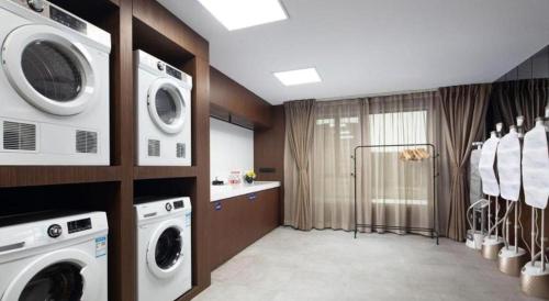 a laundry room with a washer and dryer at Hampton by Hilton Zhuhai Doumen in Zhuhai