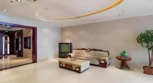 a living room with a couch and a tv at GreenTree Inn Xuzhou South Minzhu Road in Xuzhou