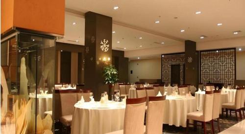 a restaurant with white tables and chairs in a room at Holiday Inn Hotel & Suites Jiaxing Hangzhou Bay By IHG in Jiaxing