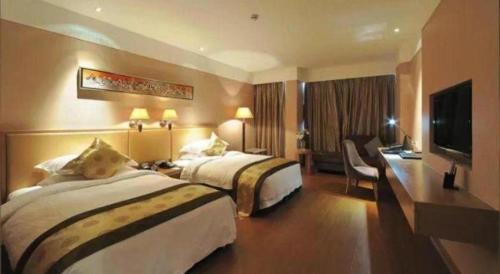a hotel room with two beds and a flat screen tv at Holiday Inn Hotel & Suites Jiaxing Hangzhou Bay By IHG in Jiaxing