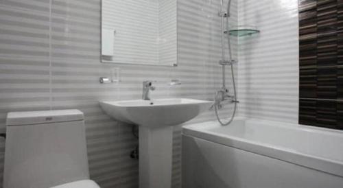 a bathroom with a sink and a toilet and a bath tub at Line Plus Hotel in Gimpo