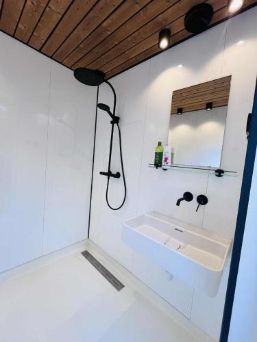 a white bathroom with a sink and a mirror at Kargevärava Elamustalu in Kapra