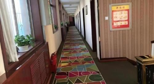 a hallway with a colorful tile floor in a building at Shell Hotel Taiyuan South Railway Station New Southeast Bus Station in Taiyuan