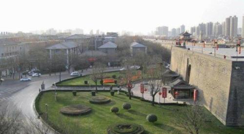 a park next to a wall with trees and bushes at Jinjiang Inn Xi'an Zhonglou North Street Metro Station in Xi'an