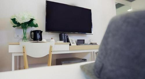 a room with a desk with a television and a table with a chair at Thaisun Bangkok Hotel in Bangkok