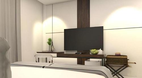 a room with a bed and a tv on a wall at Thaisun Bangkok Hotel in Bangkok