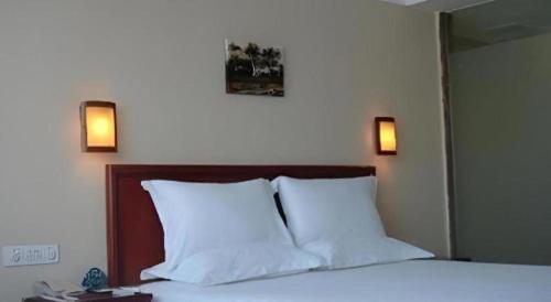 a bedroom with a bed with two lights on the wall at GreenTree Inn Nanning Langdong Hotel in Nanning
