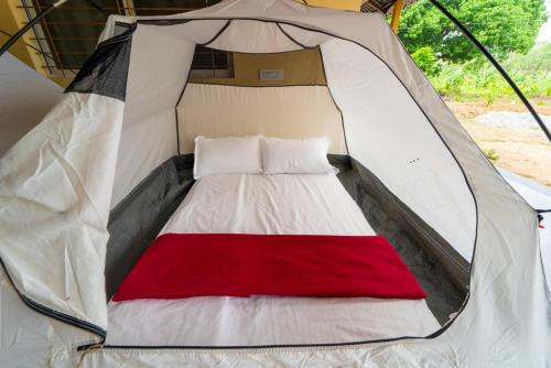 een wit en rood bed in een tent bij Dandeli Heritage Resort in Dandeli