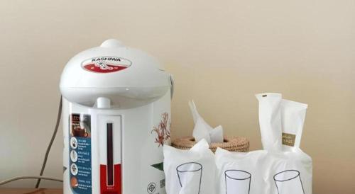 a white coffee maker sitting on top of a table at Hihotel Saraburi in Sara Buri