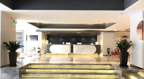 a lobby with a staircase in a building at Yitel Collection Lianyungang High-speed Railway Station Suning Plaza in Lianyungang
