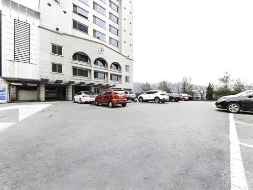 a parking lot with cars parked in front of a building at Nostalgia Hotel in Paju