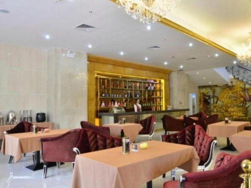 a restaurant with tables and chairs and a bar at Shenzhen Kai Long International Hotel in Shenzhen