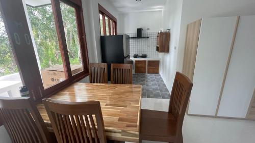 a kitchen and dining room with a wooden table and chairs at Hin Kong Hide Away 1 in Wok Tum