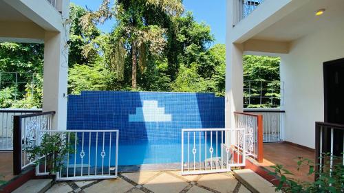 a pool in a house with a blue wall at Natures Nest In Marine Gardens in Candolim