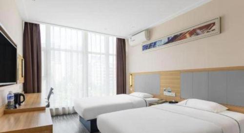 a hotel room with two beds and a window at City Comfort Inn Beihai RT-Mart High Speed Railway Station in Beihai