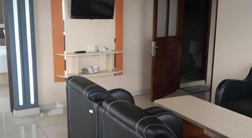 a room with chairs and a table and a tv at Samosir Cottages Resort in Tuk Tuk