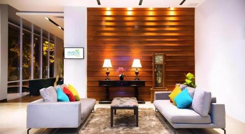 a living room with two couches and a piano at Ayola First Point Hotel Pekanbaru in Pekanbaru