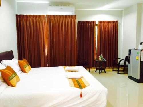 a bedroom with a white bed with orange pillows at Retro Twin Home @Maesot in Mae Sot