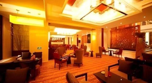 a lobby with tables and chairs in a restaurant at Ramada Plaza by Wyndham Yangzhou Casa in Yangzhou