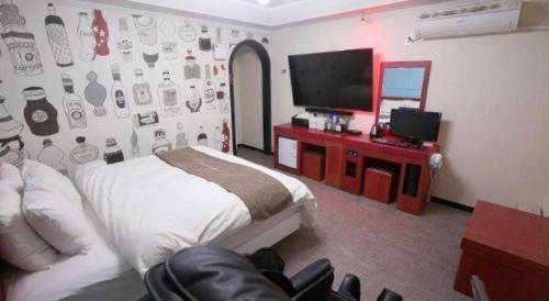 a bedroom with a bed and a flat screen tv at Luxury Motel Daejeon in Daejeon