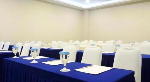 a conference room with blue tables and white chairs at Zenith Hotel in Kendari