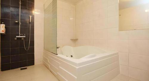 a white bathroom with a tub and a shower at Hotel Casa Suwon in Suwon