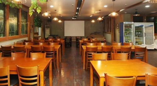a dining room with wooden tables and chairs at Hotel Casa Suwon in Suwon