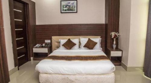 a bedroom with a large bed and two night stands at Hotel Gajur Palace in Itahari