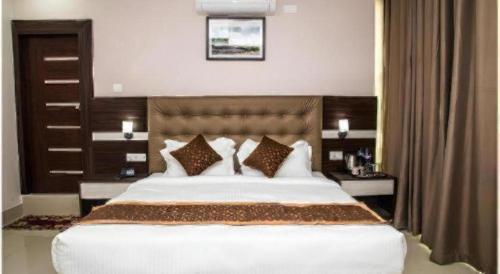 a bedroom with a large white bed with pillows at Hotel Gajur Palace in Itahari