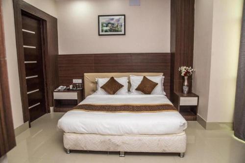 a bedroom with a large bed and two tables at Hotel Gajur Palace in Itahari