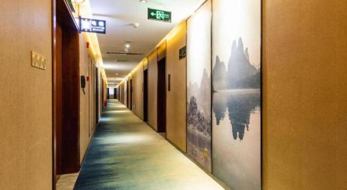 a corridor of a hallway with paintings on the walls at Guilin Manhatton Hotel Tianjie in Guilin