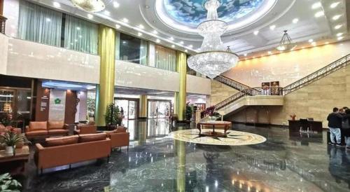 a lobby of a building with a chandelier at Golden Lustre Hotel in Shenzhen