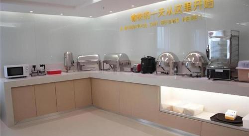 a kitchen with a counter with microwaves and appliances at City Comfort Inn Foshan Shunde Daliang Qinghui Garden Xinsong in Shunde