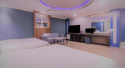 a hotel room with two beds and a television at Hotel Head-One in Uijeongbu
