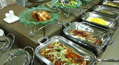 a buffet with several trays of food on a table at Benikea Ariul Hotel in Gunsan