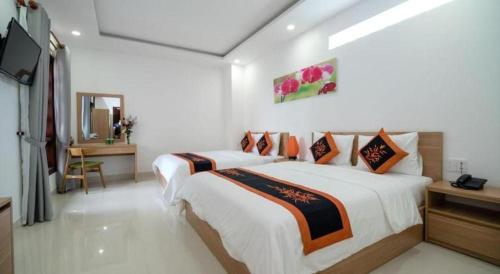 a hotel room with two beds and a television at Kim's Villa Hoi An in Hoi An
