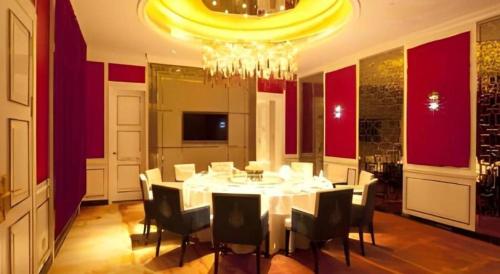 a dining room with a table and chairs and a chandelier at Changchun Zhuozhan Days Hotel in Changchun