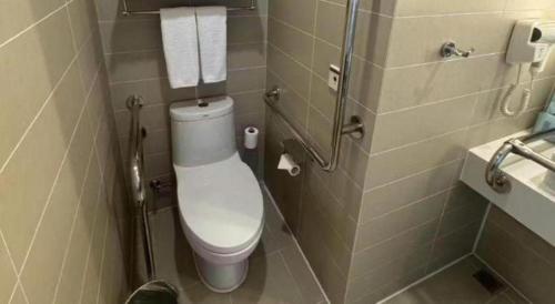 a small bathroom with a toilet and a sink at Holiday Inn Express Handan East By IHG in Handan