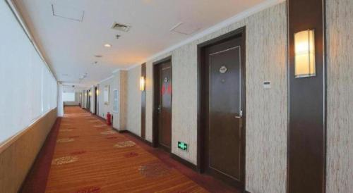 a hallway of an office with wooden floors and doors at Changchun Zhuozhan Days Hotel in Changchun