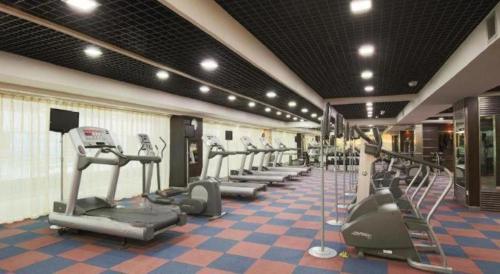a gym with a row of treadms and machines at Changchun Zhuozhan Days Hotel in Changchun