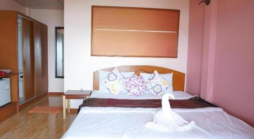 a bedroom with a large bed in a pink room at Wanghin Bungalow in Surat Thani
