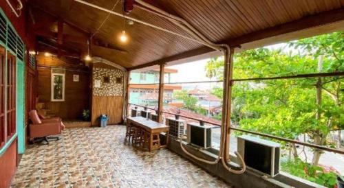 a balcony of a house with a table and several televisions at Bunda House Syariah in Padang