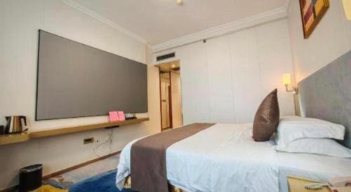 a bedroom with a large projection screen on the wall at Nanning Yongzhou Hotel in Nanning