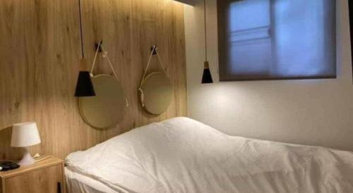 a bedroom with a bed and two mirrors on the wall at THE GOOSE HOUSE UBON in Ubon Ratchathani