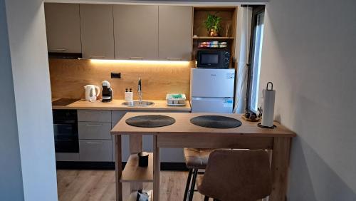 a small kitchen with a table and a refrigerator at Apartman 19 Vinkovci, klimatiziran, self check-in in Vinkovci
