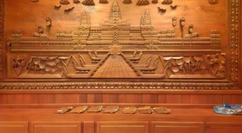 a wooden wall with a carving of a temple at Asia Hotel in Phnom Penh