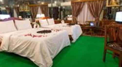 a room with white tables and a green floor at Asia Hotel in Phnom Penh