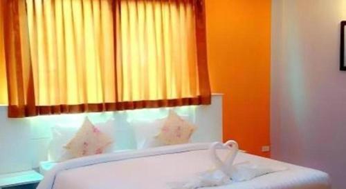 a bed in a room with a window at Waenpetch place Hotel in Ubon Ratchathani