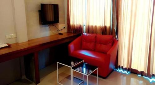 a red chair sitting in front of a desk at Waenpetch place Hotel in Ubon Ratchathani